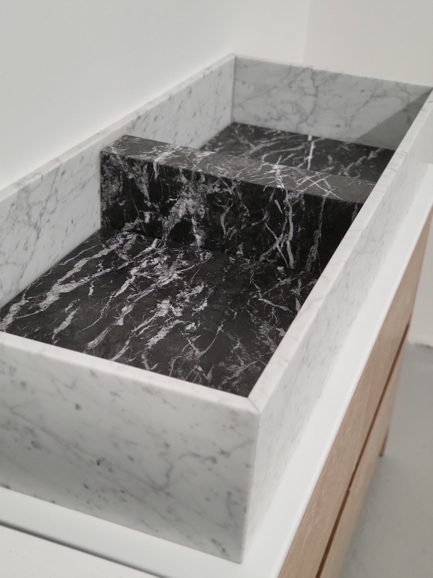 Carrara & Nero Marquina sit on basin