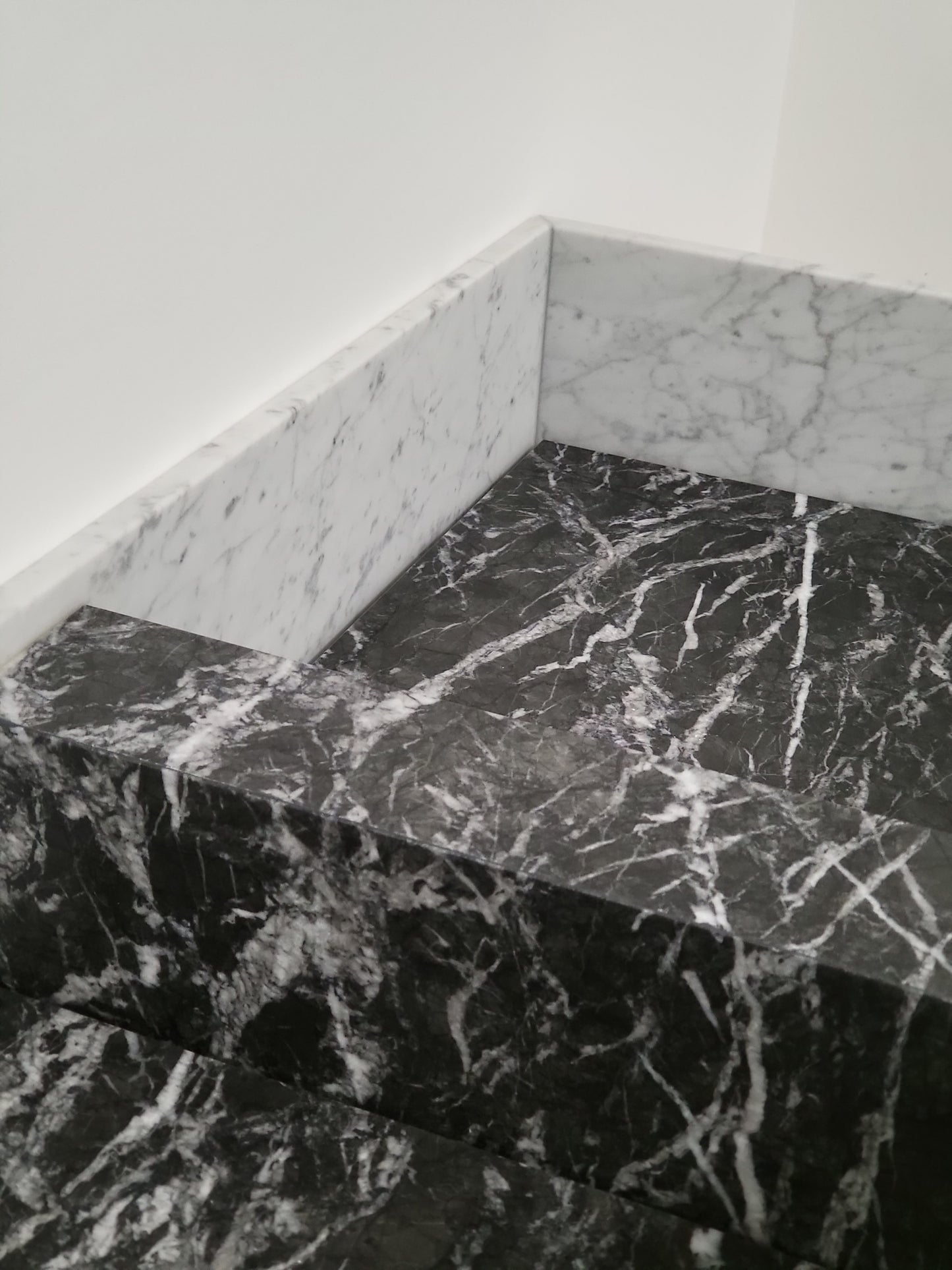 Carrara & Nero Marquina sit on basin