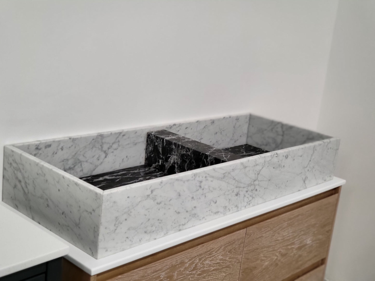 Carrara & Nero Marquina sit on basin