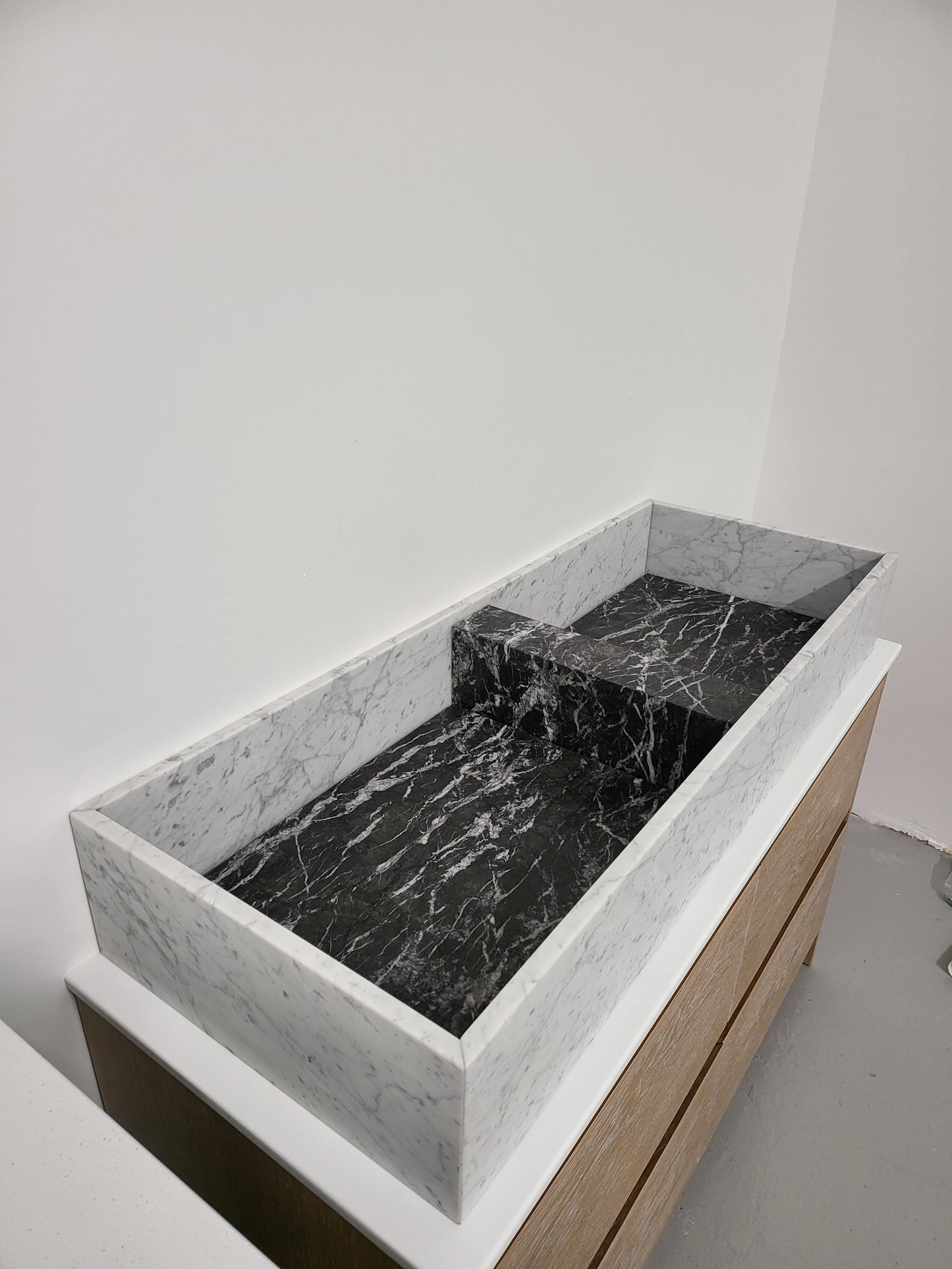 Carrara & Nero Marquina sit on basin