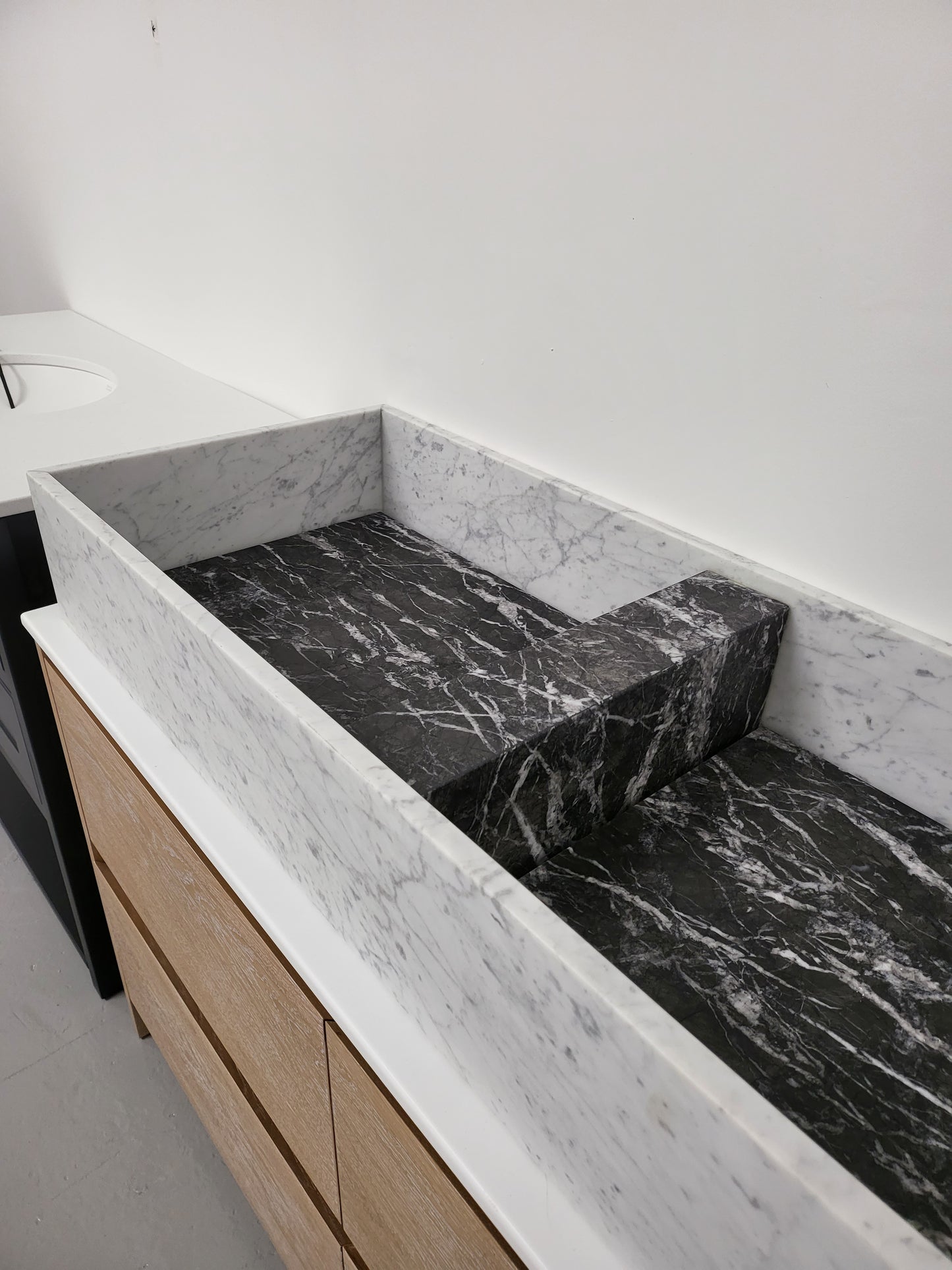 Carrara & Nero Marquina sit on basin