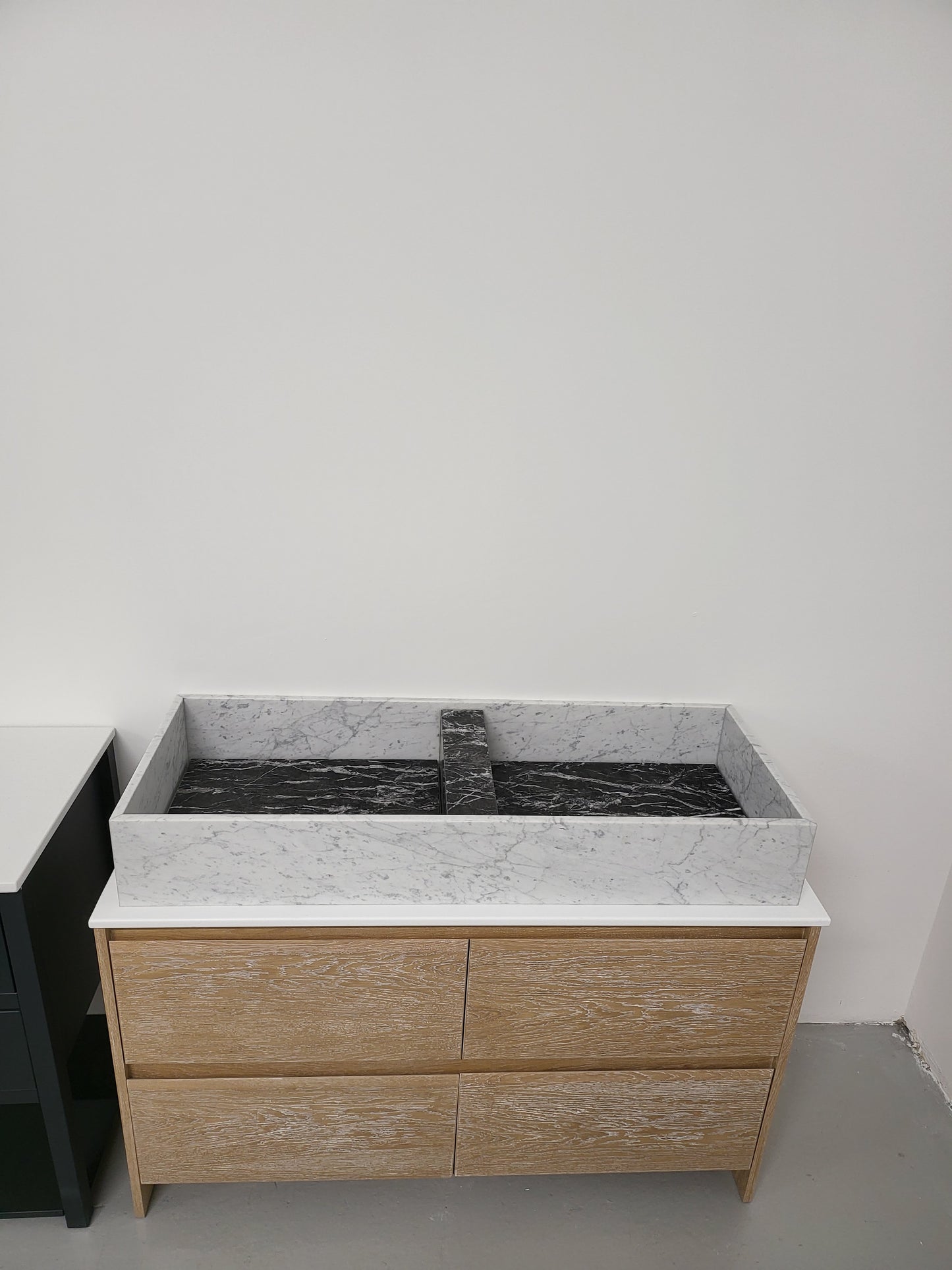 Carrara & Nero Marquina sit on basin